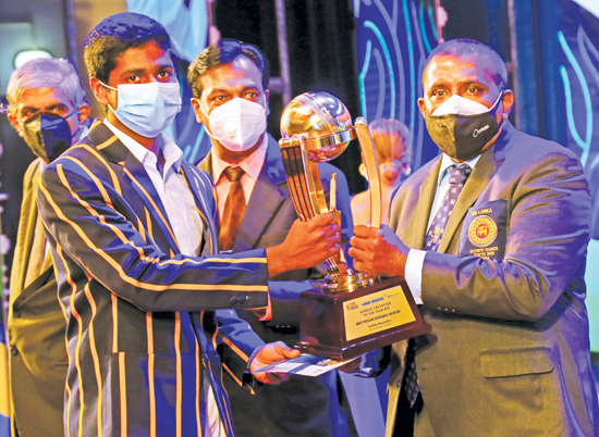 Sadisha Rajapaksa of Royal College who was elected as the Most Popular School Cricketer for the year 2021was unable attend the Awards ceremony due to commitment with the U-19 Cricket squad preparing to meet the England U-19 team. Picture shows a representative receiving the coveted Award from Editor-in Chief Sunday Observer Dinesh Weerawansa on Behalf of Sadisha Rajapaksa